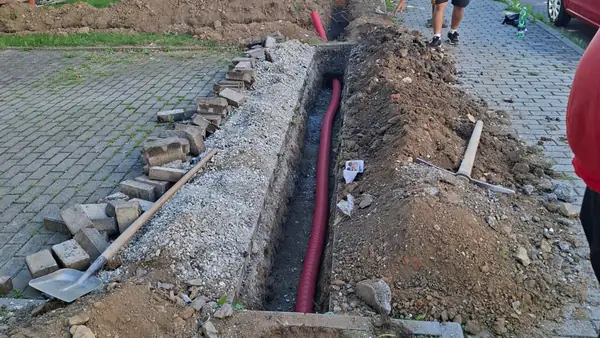 Výkop pro kabelovou trasu podél chodníku