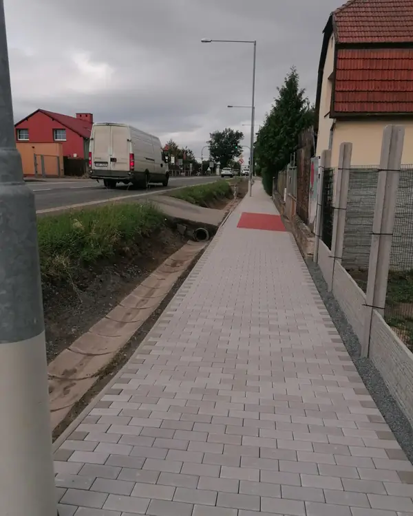 Dokončený chodník ze zámkové dlažby s varovným pásem